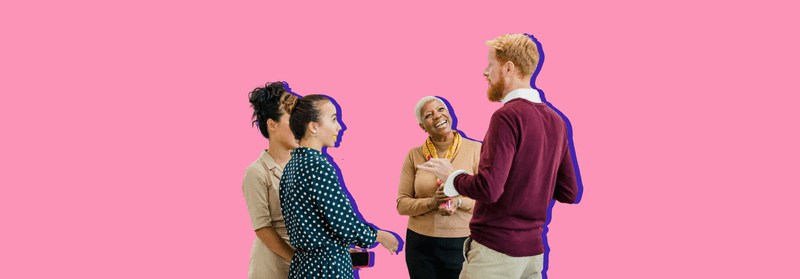 A small group of colleagues talking together in a relaxed meeting, set against a pink background.