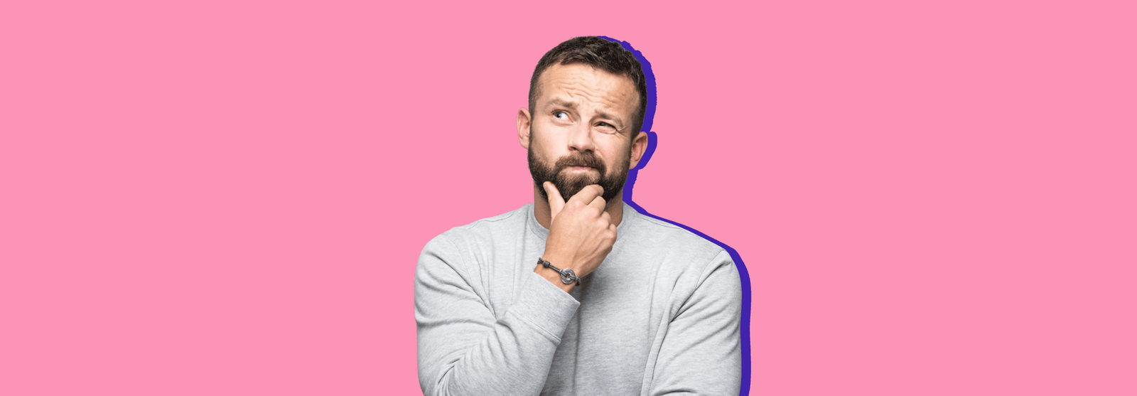 A bearded man resting a hand on his chin in thought, set against a pink background.