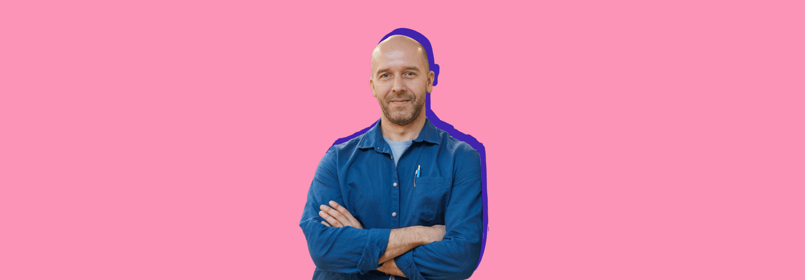 A smiling bald man in a denim shirt with his arms crossed, set against a pink background.