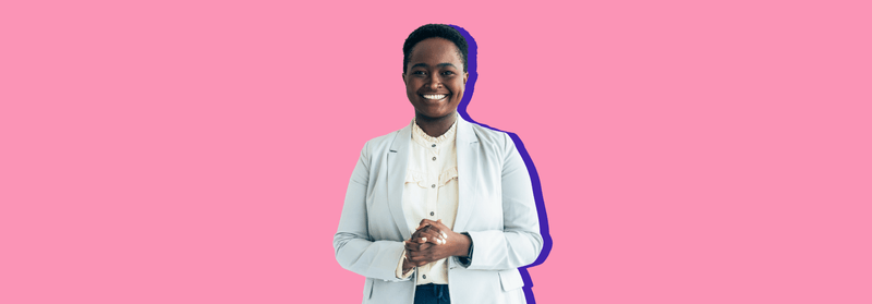 A smiling Black woman in a white blazer with her hands clasped, set against a pink background.